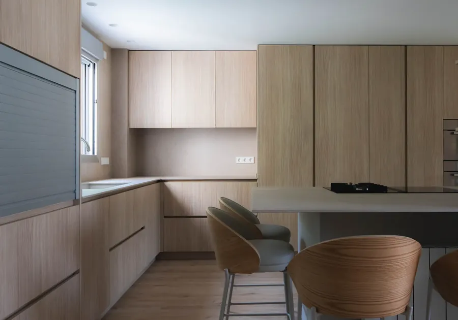 Cocina Casa Fogó Alfinach con taburetes, office y columnas de almacenaje